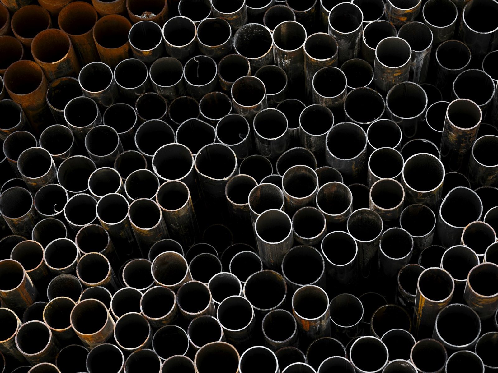Stacked dark mild steel pipes